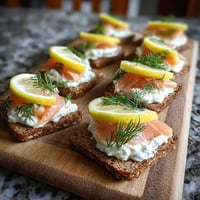 Eine Schüssel mit Rye Canapés, die mit Smoked Trout garniert sind.